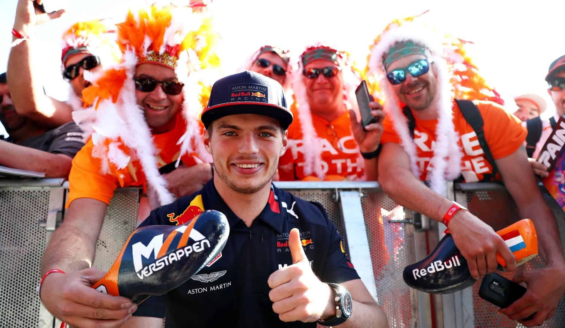 Max Verstappen posing infront of the camera with fans behind him