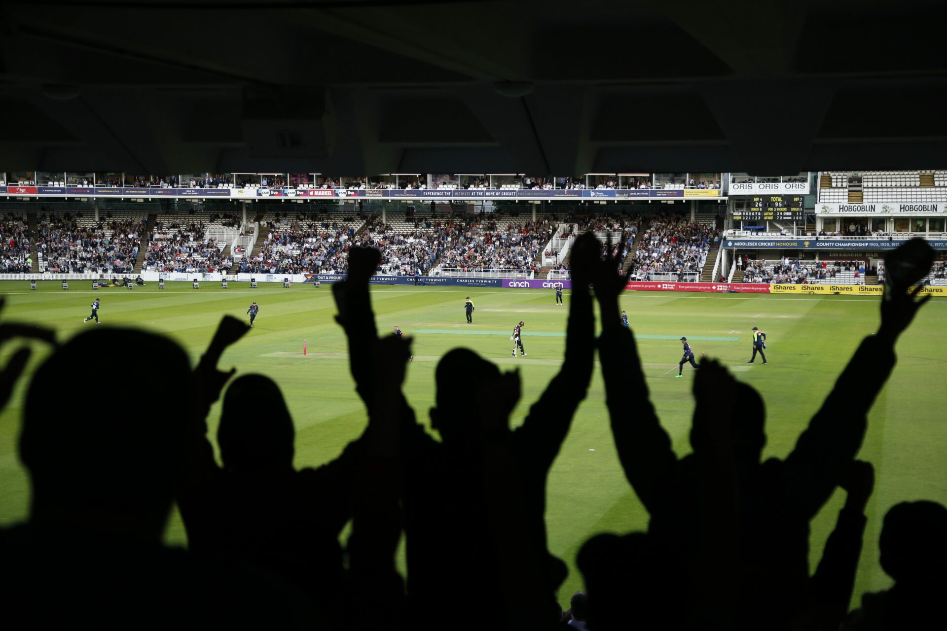 Crowd cheering in the stands during a cricket match